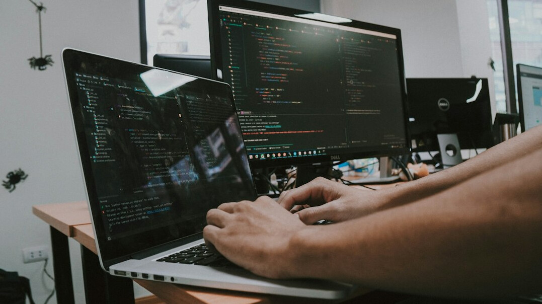 person coding on laptop